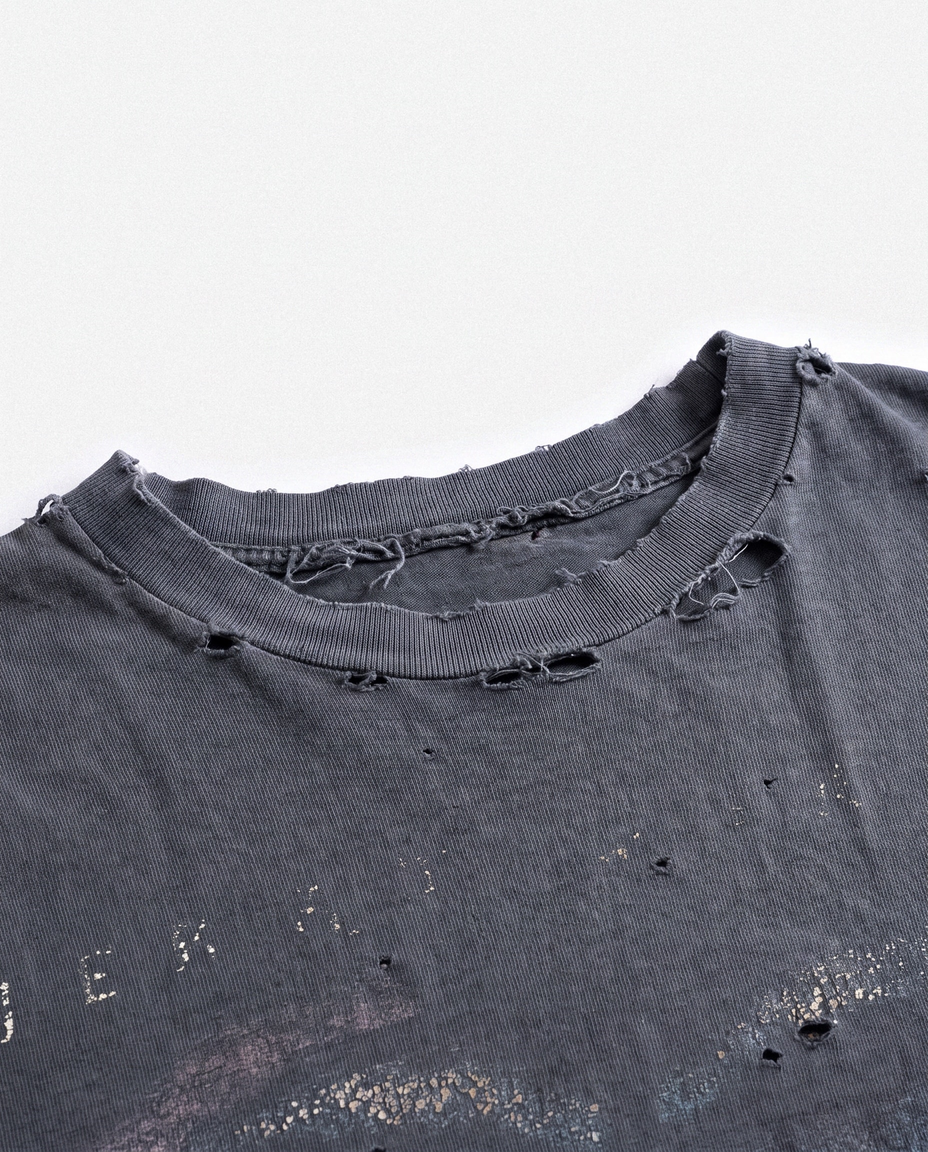 Close-up of the frayed collar of a washed charcoal tee